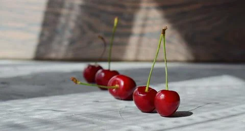 Cherry berry lying in a row on a gray background Stock Photos