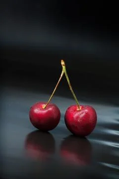 Cherry on black reflective background Stock Photos