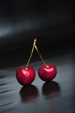 Cherry on black reflective background Stock Photos