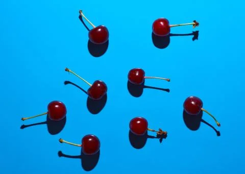 Cherry on blue background with shadows effect Stock Photos