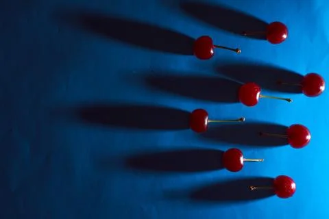 Cherry on blue background with shadows effect Stock Photos