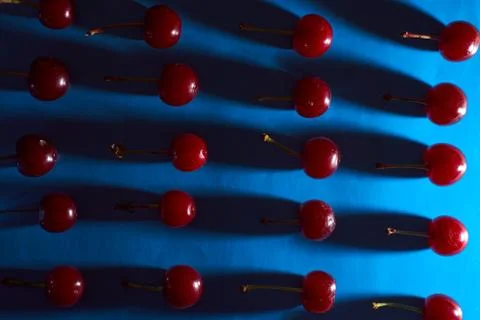 Cherry on blue background with shadows effect Stock Photos