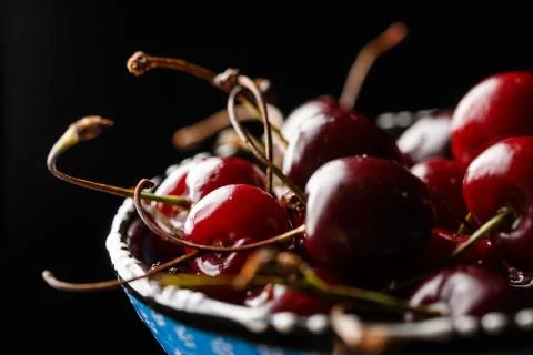 Cherry in a bowl close-up on a black background Stock Photos