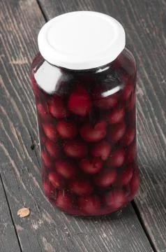 Cherry compote in a glass jar Stock Photos