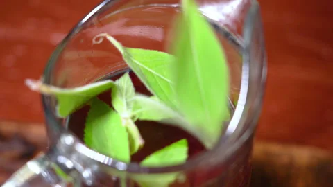 Cherry compote in a jug with pieces of mint Stock Footage 253717293