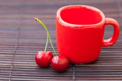 Cherry cup on bamboo mat Stock Photos