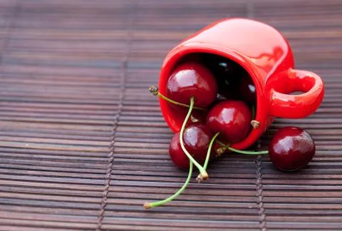 Cherry cup on bamboo mat Stock Photos