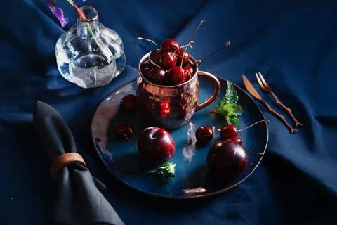 Cherry in a cup on a dark background Stock Photos