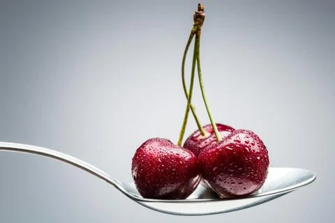 Cherry on curved spoon Stock Photos