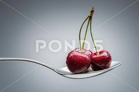 Cherry on curved spoon Stock Photos