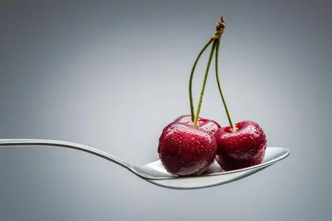 Cherry on curved spoon Stock Photos