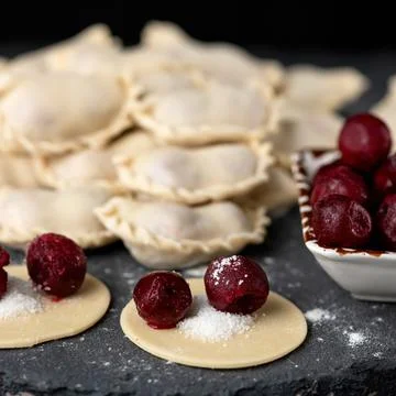Cherry Dumplings, Cooking process. Red berry and sugar filling on rolling Raw Stock Photos