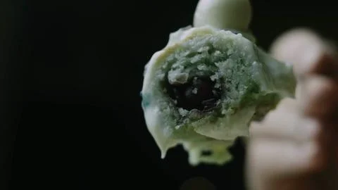 Cherry filled cake bite held close to the camera Stock Photos