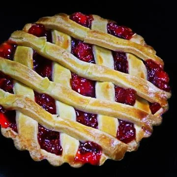 Cherry filled pie in close up with black background Stock Photos