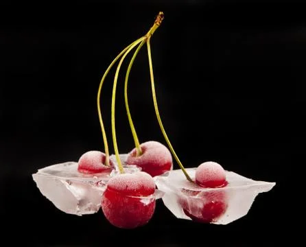 Cherry in ice on a black background Stock Photos