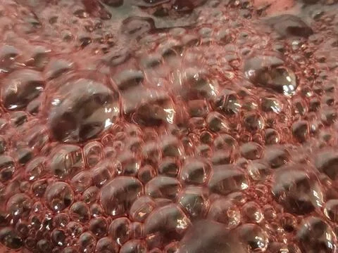 Cherry jam. Boiling jam surface. Background of bubbles on cherry jam Stock Photos