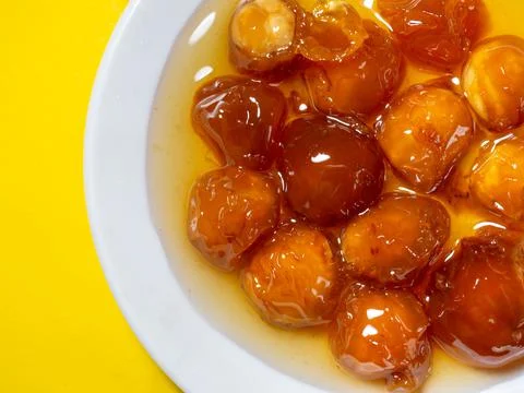 Cherry jam stuffed with nuts. Sweet treat. Jam in a bowl for tea. Yellow jam  Stock Photos