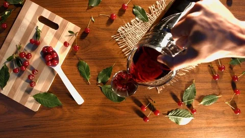 Cherry juice and cherry on the table. Видео 79612539