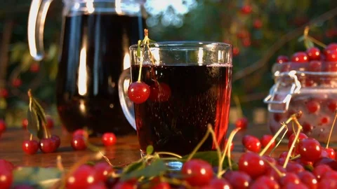 Cherry juice on the background of growing cherries. Stock Footage 79612088