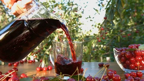 Cherry juice on the background of growing cherries. Stockbeeldmateriaal 79612768