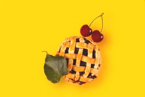 Cherry mini pie with ripe cherries on a bright yellow background Stock Photos