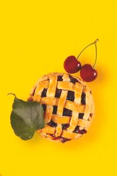 Cherry mini pie with ripe cherries on a bright yellow background Stock Photos