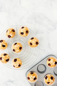 Cherry Muffins in Baking Form and on Cooling Rack over Marble Background with Stock Photos