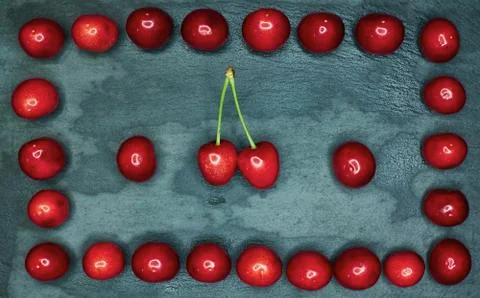 The cherry rests in a frame on a black background Stock Photos