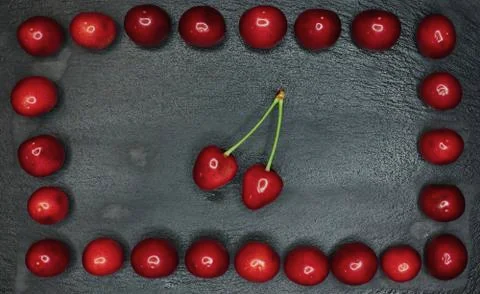Cherry with a tail framed from cherry on a black background Stock Photos