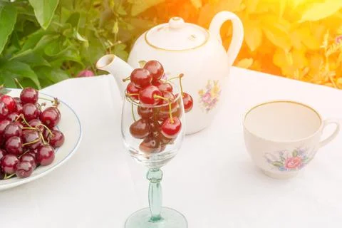 Cherry tea cup glass table in a garden courtyard for summer tablecloth select Stock Photos