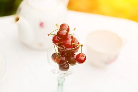 Cherry tea cup glass table in a garden courtyard for summer tablecloth select Stock Photos