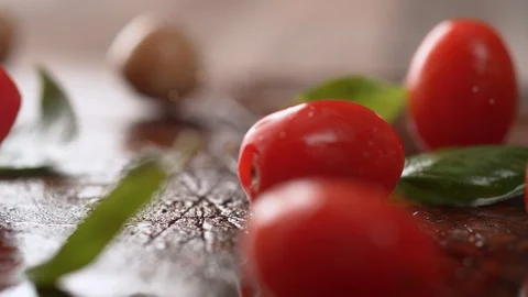 Cherry tomato and mozzarella cheese rolling over fresh basil. Slow Motion. Stock Footage 104459831