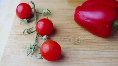 Cherry tomato and red capsicum cutting on a chopping board close view. Video stock 149517315