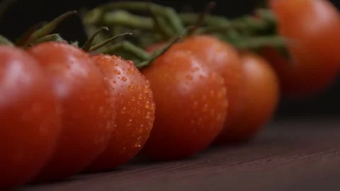 Cherry tomato branches on wooden surface, dark background, camera movement, sele Video stock 267603653