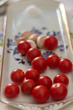 Cherry tomato with garlic on a table Stock Photos