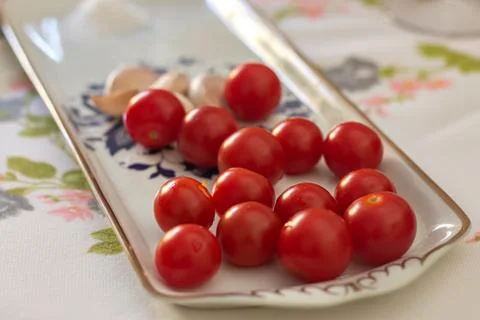Cherry tomato with garlic on a table Stock Photos