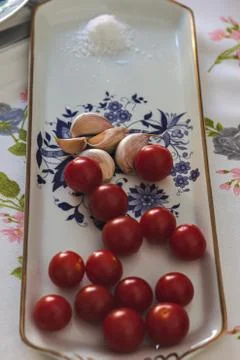 Cherry tomato with garlic on a table Stock Photos