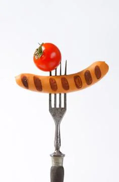 Cherry tomato on a sausage with fork Stock Photos