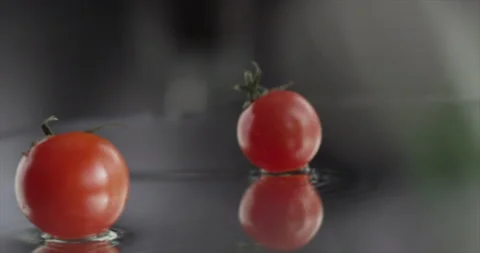Cherry tomato spinning on a mirror surface Stock Footage 201112905