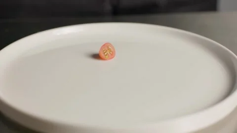 Cherry tomatoes being dropped and arranged on a white plate Video stock 313029831
