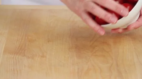 Cherry tomatoes being placed on a work surface Stock Footage 24656386