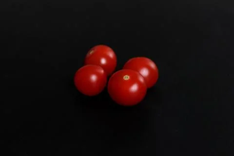 Cherry tomatoes on a black background Stock Photos