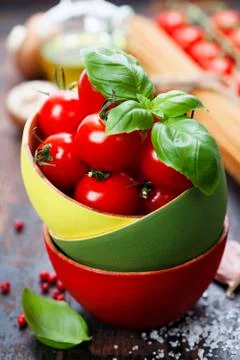 Cherry tomatoes in a bowl with basil Stock Photos