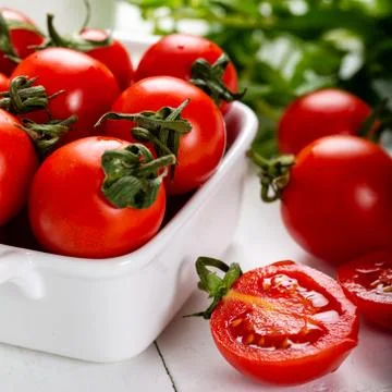 Cherry tomatoes in a bowl with basil Stock Photos