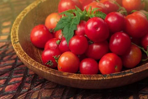 Cherry tomatoes in bowl on rustic table 写真素材