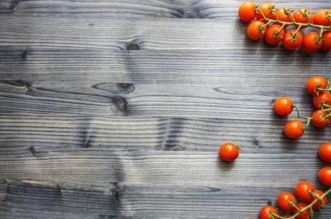 Cherry tomatoes on a branch on a black rustic wooden table Stock Photos