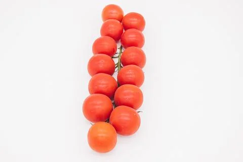 Cherry tomatoes on branch stand on white background Stock Photos