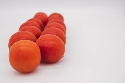 Cherry tomatoes on branch stand on white background Stock Photos