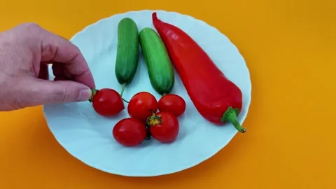 Cherry Tomatoes, Chili, Cucumbers Styled on Vibrant Orange Surface Video stock 323164541