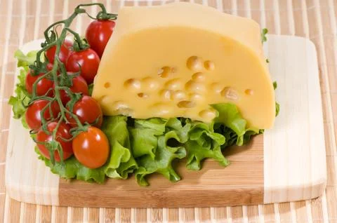Cherry tomatoes cluster and yellow cheese Stock Photos